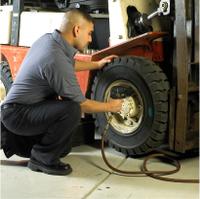 Tire Sale - tech using air wrench on forklift wheel